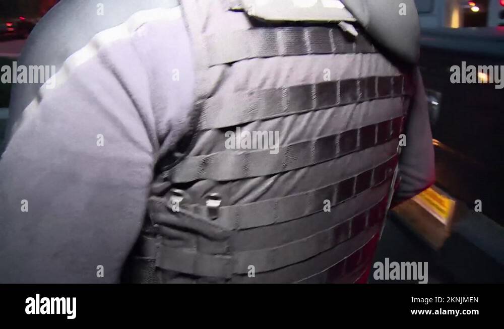 2010s police officers escorting handcuffed individuals to police car