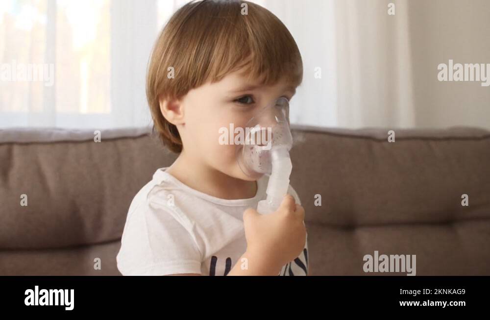 Little girl holding a mask nebulizer inhaling fumes medication into lungs. Child Stock Video