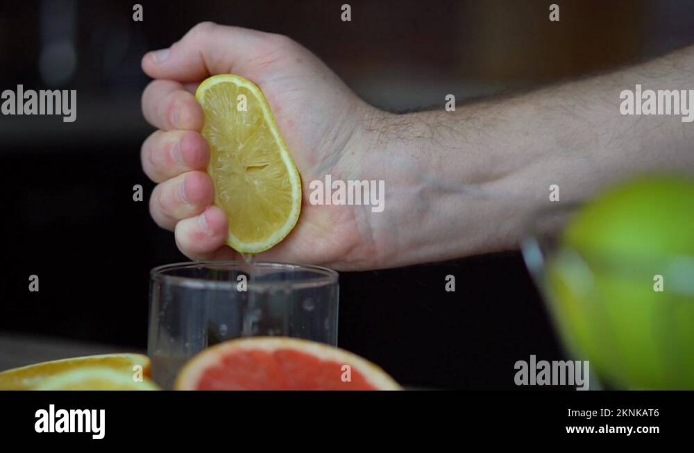 Male hands are squeezing ripe lemon for making citrus juice , healthy