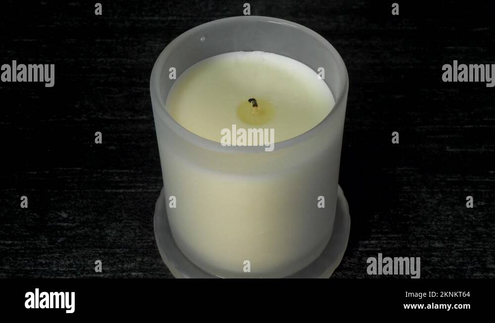 Wet finger and thumb putting out a candle, then replacing its cover