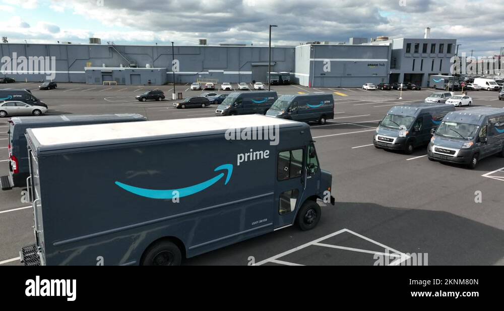 Rising aerial of Amazon Prime delivery truck at warehouse hub. Delivery