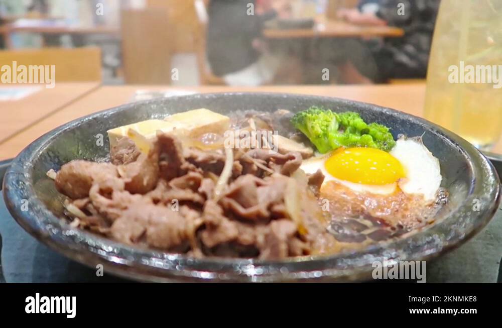 Japanese food Cooking hot pan with smoke over slice beef tofu egg