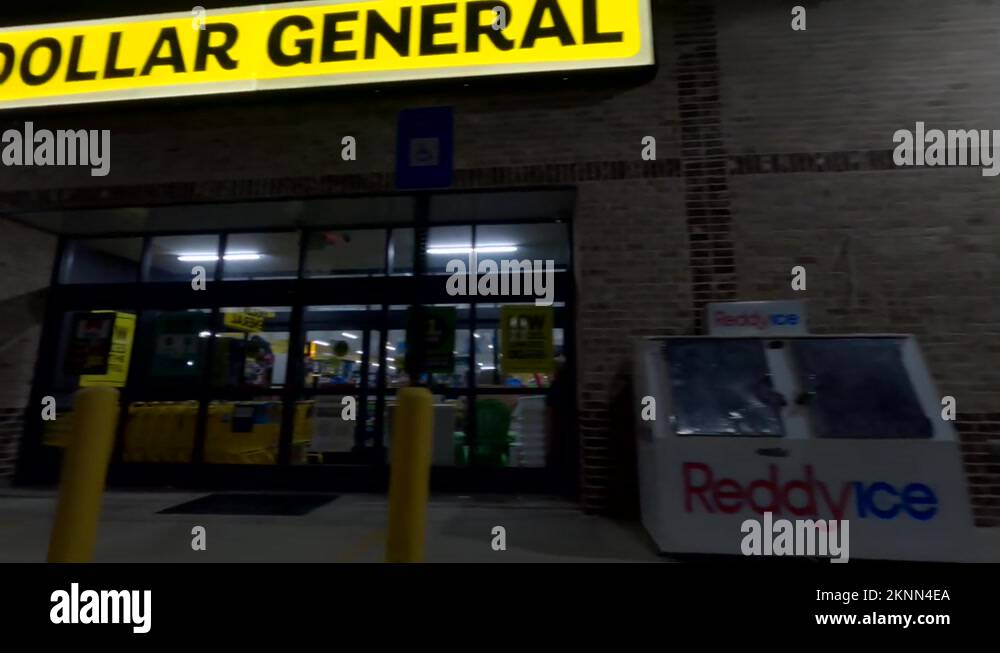 Close up pan of a closed Dollar General retail store at night Stock