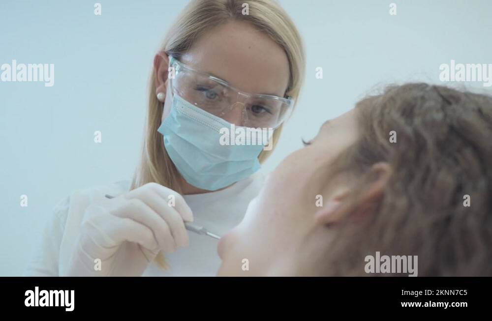 Female dentist doing an exam of teeth and gums of a female patient