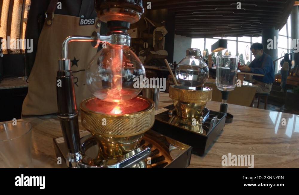 Barista making coffee with syphon at Starbucks coffee shop in Bangkok