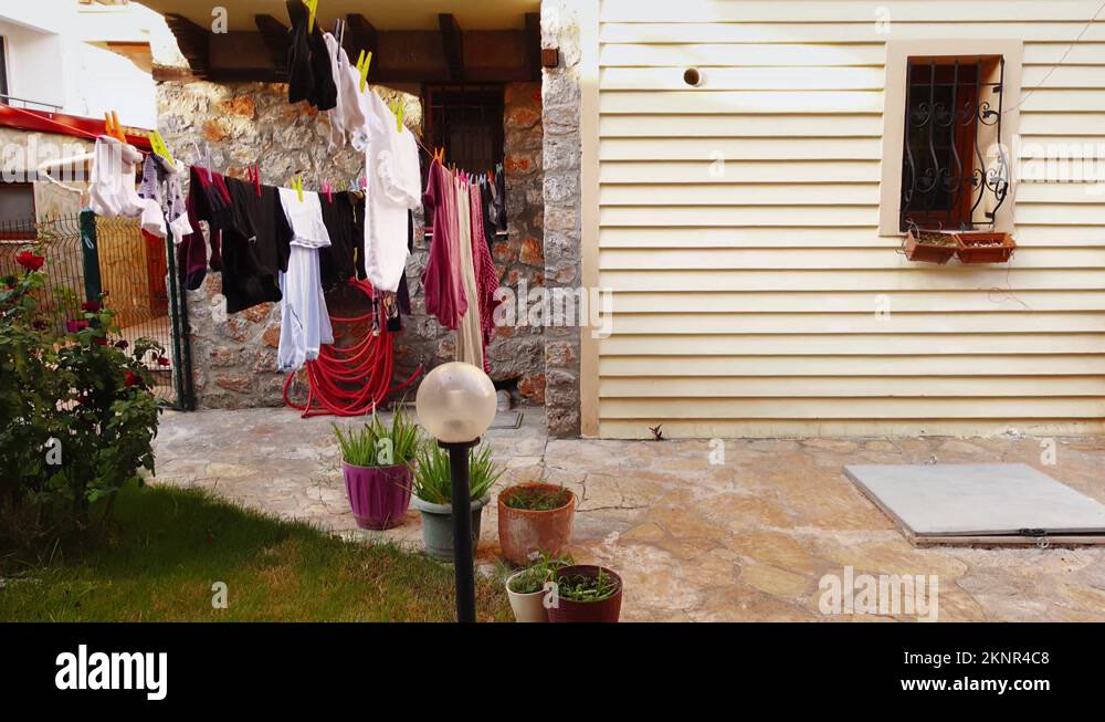 Clean wet clothes are hanging on the clothesline and drying after being
