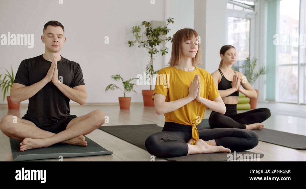 Namaste. Relaxing after group exercises in class room. Yoga Club
