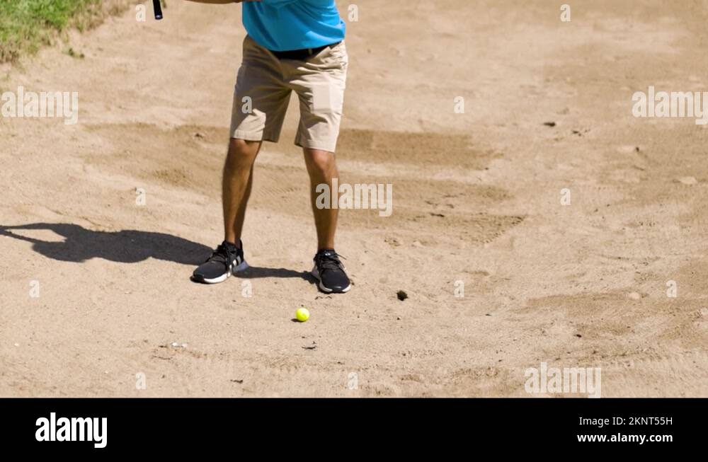 Golfer hitting a golf ball with a sand wedge out of the sand pit Stock