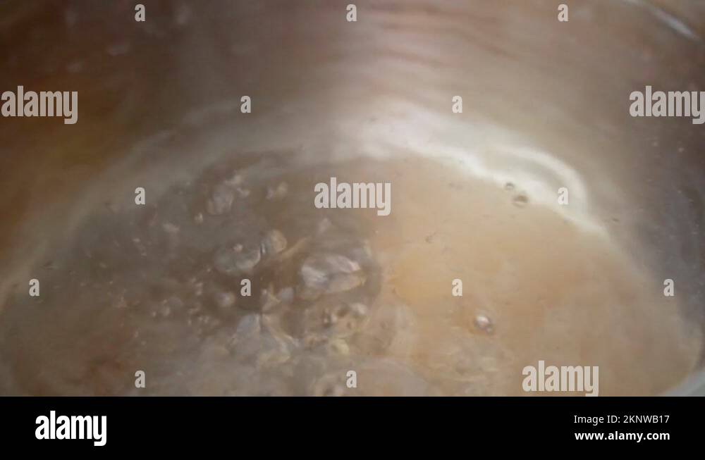 Pot with boiling water on electric stove. Closeup. Bubbles of boiling