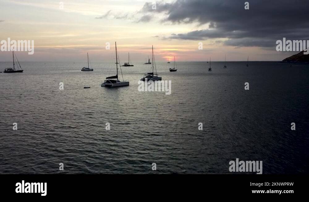 Sailing catamarans and other sailing vessels are anchored in the bay ...