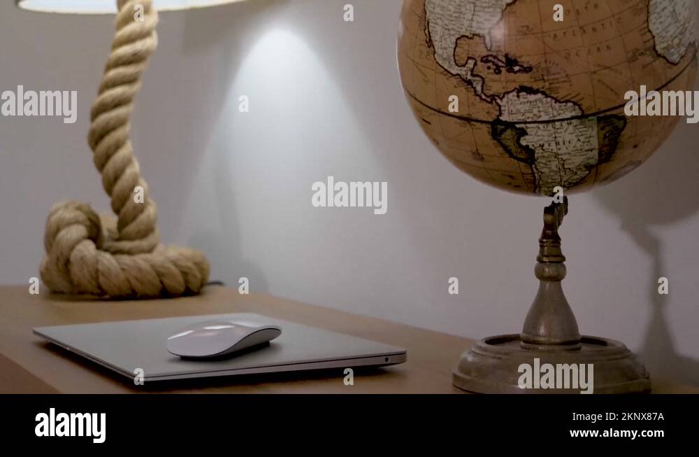 Rope made lamp, laptop with mouse and an Earth globe on a wood desk ...
