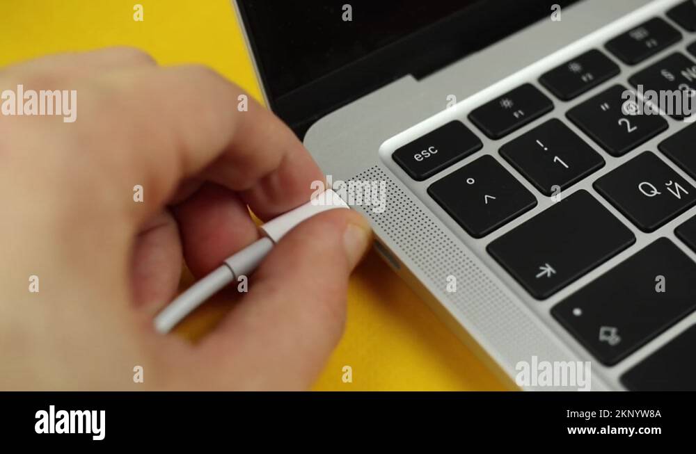 Person hand pull out or extract a USBC cable charger from computer or