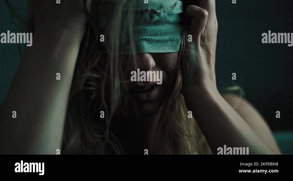 unhappy blind woman sits alone in a dark room with covered eyes, close