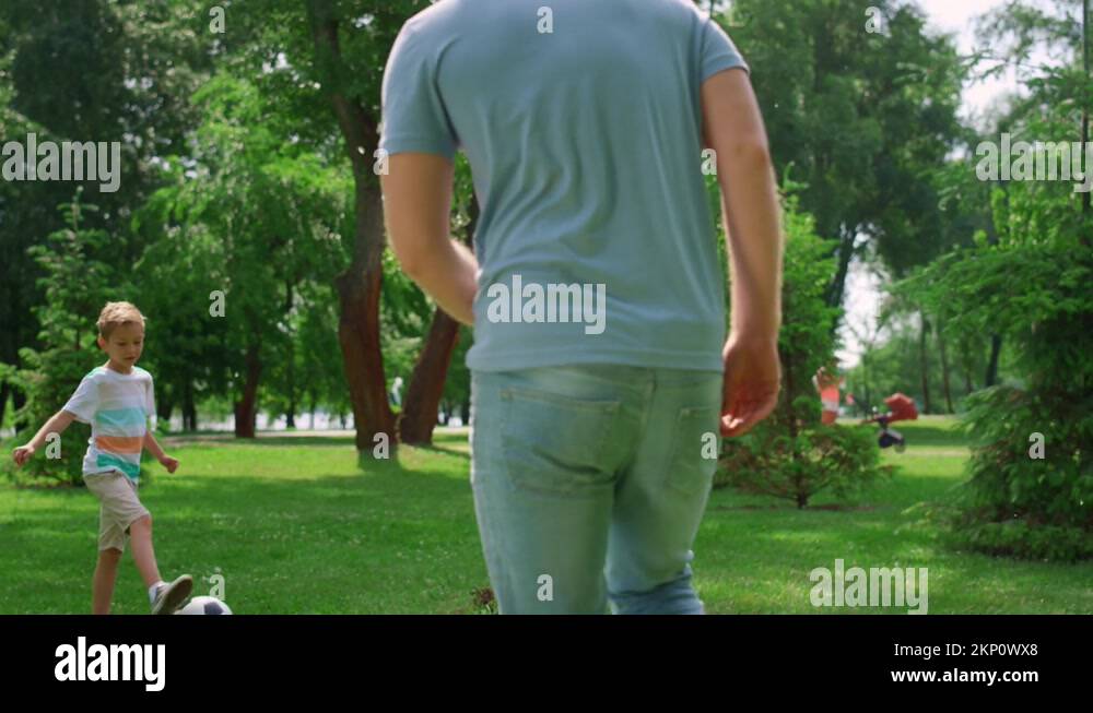 Boy make football exercise with father closeup. Family play soccer
