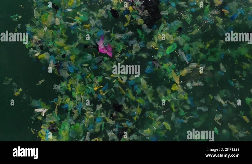 Ocean waves full of plastic waste. Global rubbish problem. Aerial top ...