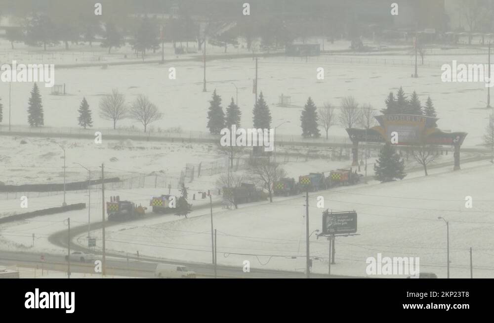 snow plow trucks driving along highway in Canada after a storm during
