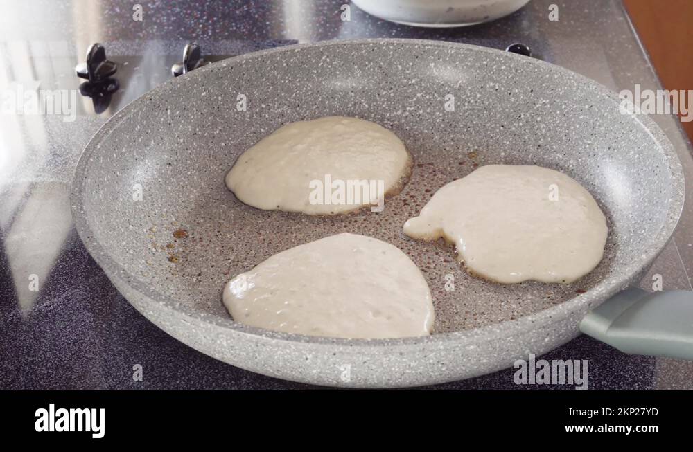 Frying kefir based pancakes in cooking pan on an electric stove Stock