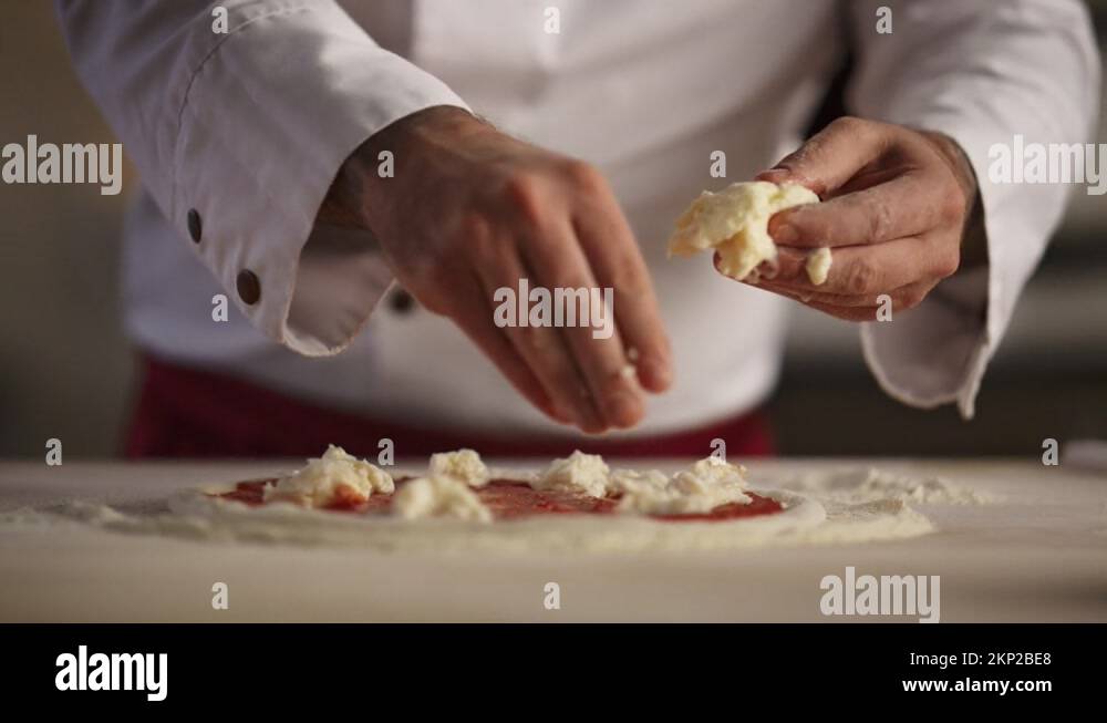 Pizza chef cooking meal in restaurant. Man hands put mozzarella cheese