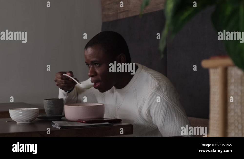 Black man eating soup in a Thai restaurant Stock Video Footage Alamy