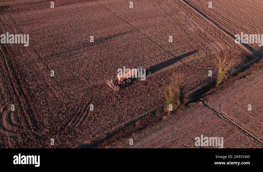 A rotary harrow with a tanker working on a land Stock Video Footage Alamy