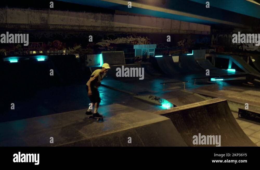 Sporty athlete preparing skateboard competition on ramp at night skate ...