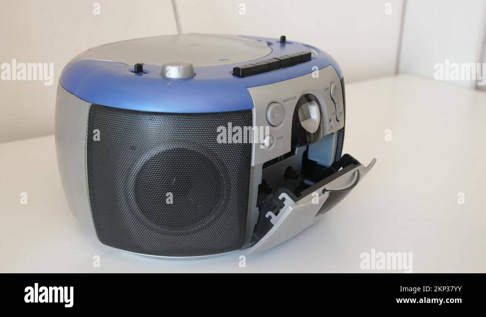 female inserting audio cassette in portable radio and pushes play