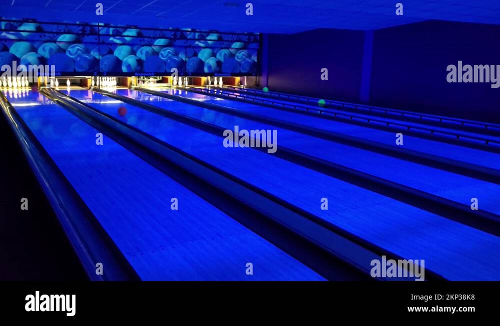 Bowling Balls Released And Roll On The Lanes Toward Pins In An Indoor