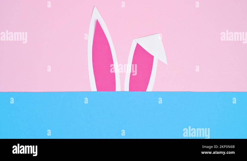 Rabbit ears appear on pastel pink and blue background. Easter stop