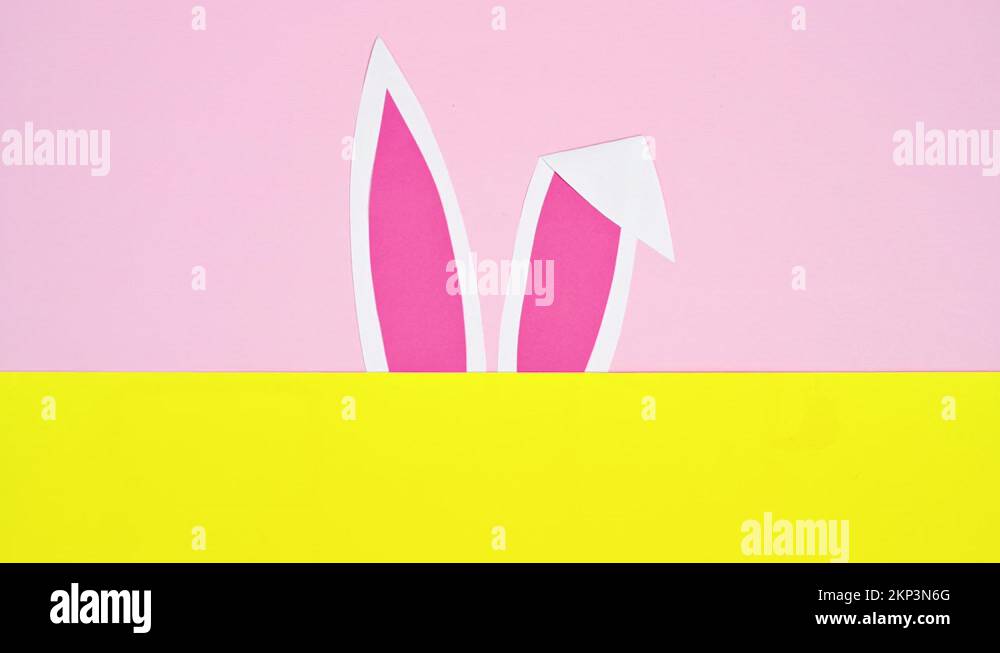 Rabbit ears appear on pastel pink and yellow background. Easter stop