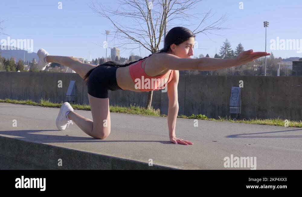 Woman doing yoga table top pose routine with one arm and leg extending