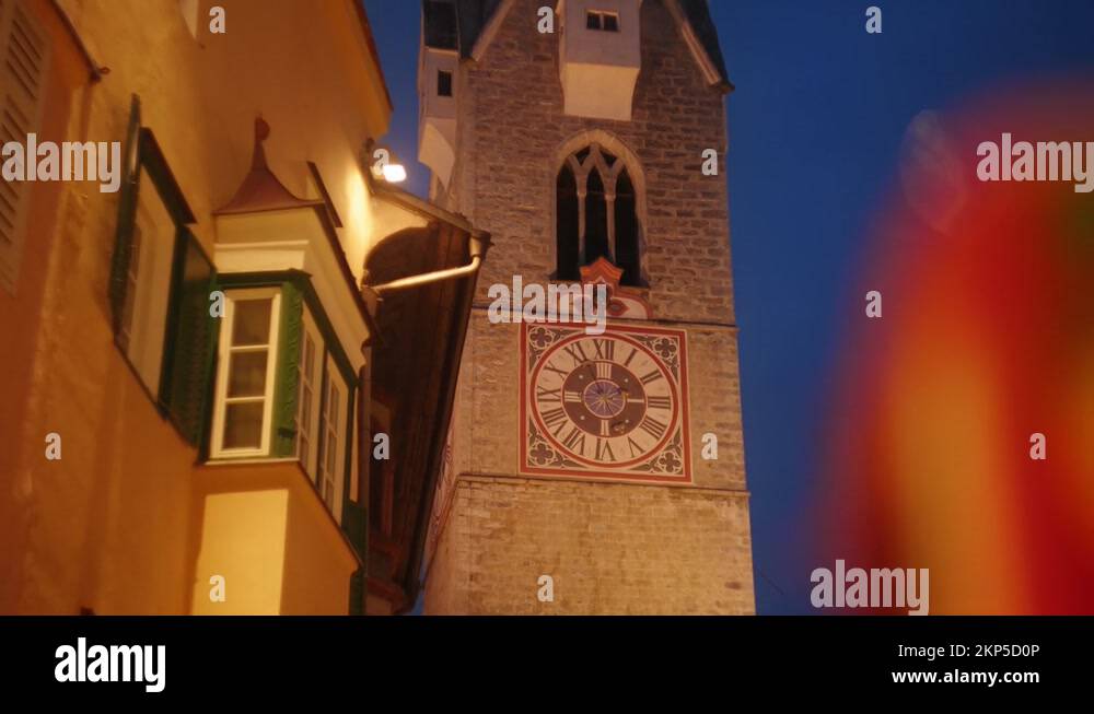 Illuminated traditional clock tower in a old italian historical town ...