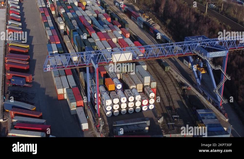 Shipping container crane lift unloading heavy cargo export crate Stock