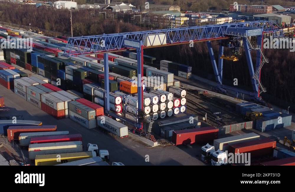 Shipping container crane lift unloading heavy cargo export crate Stock