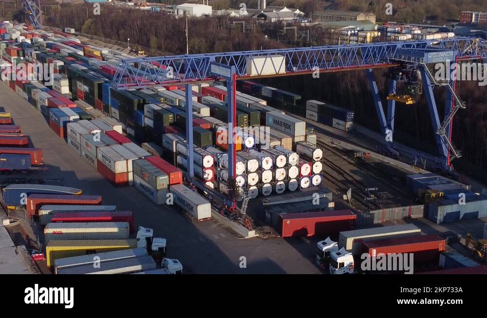 Shipping container crane lift unloading heavy cargo export crate Stock