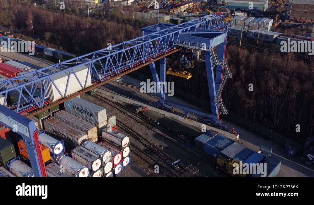 Shipping container crane lift unloading heavy cargo export crate Stock