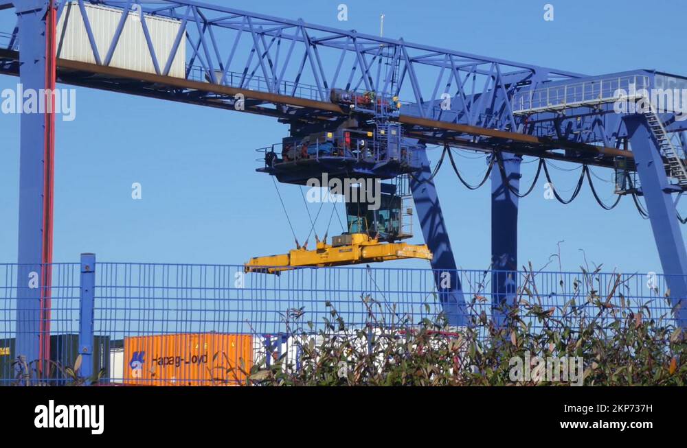Shipping container crane lift loading heavy cargo shipyard crate Stock