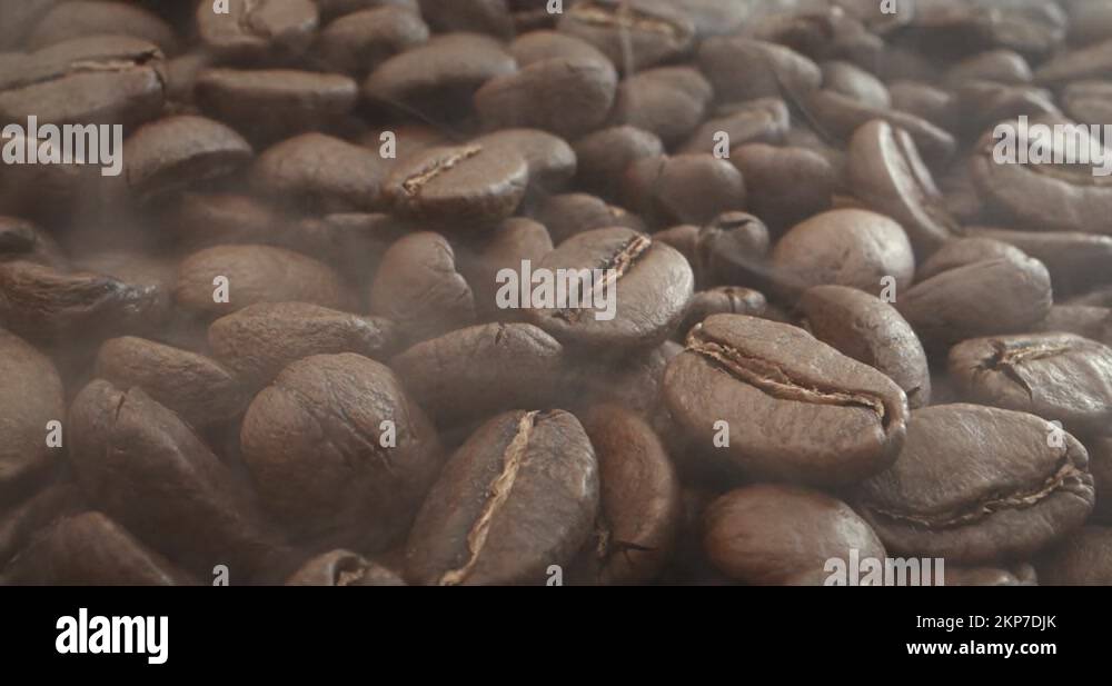 Macro shot roasting coffee beans, filmed in a dark key the smoke ...