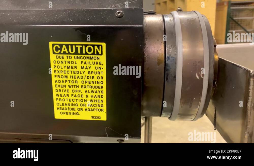 Caution sign on extruder machine for extrusion manufacturing process ...