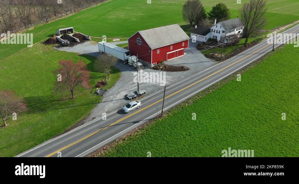 Red barn with PA Dutch Amish hex sign and white farmhouse. Mulch business Stock Video Footage