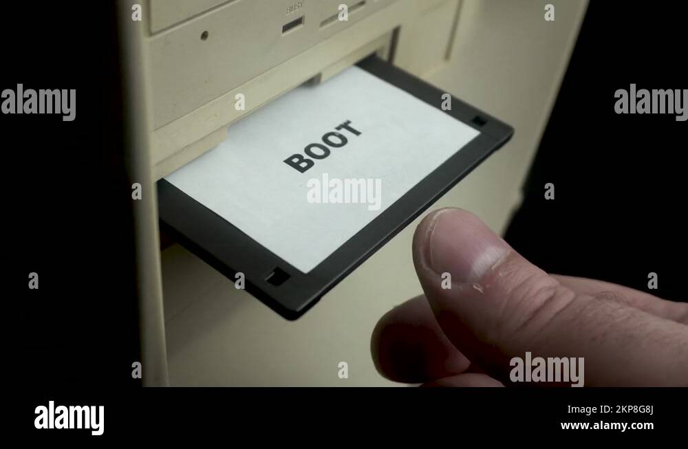 Boot Floppy Disk, Hand Inserting Diskette Into PC Drive, Close Up Stock