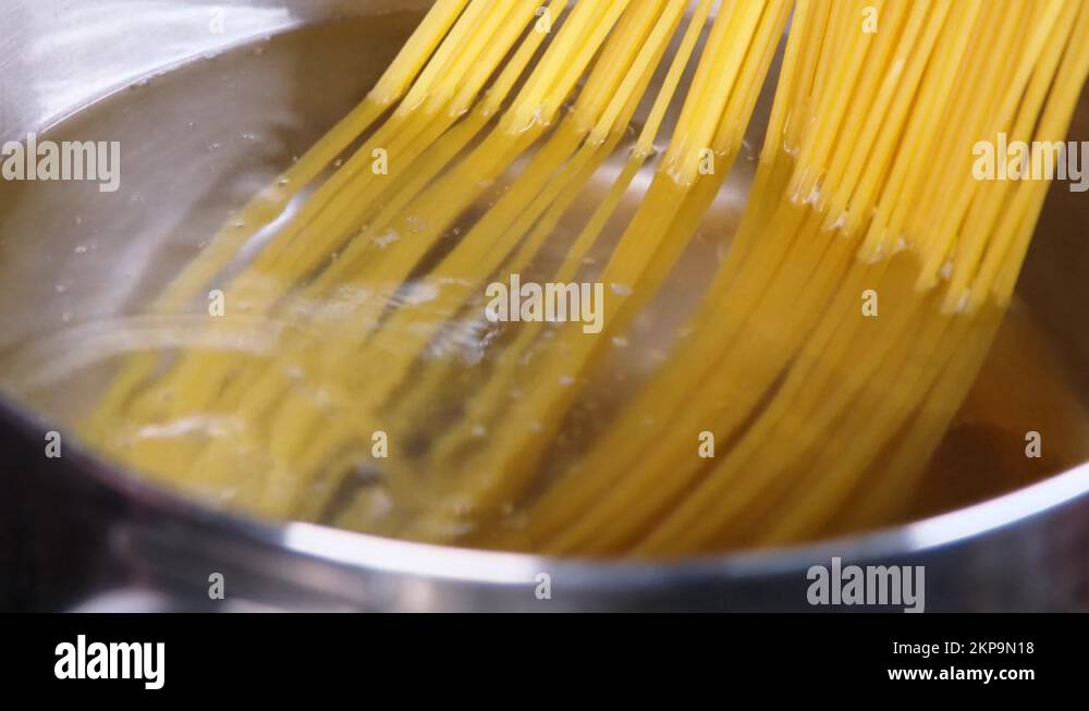 Closeup of spaghetti pasta In boiling hot water in steel pan on