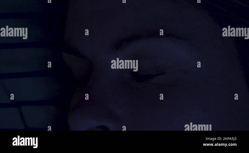Extreme close of woman's closed eyes while sleeping in bed at night Stock Video Footage Alamy