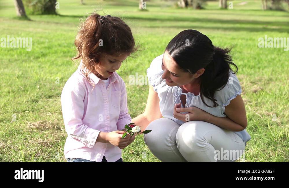 Little girl smelling a flower with mother Stock Video Footage - Alamy