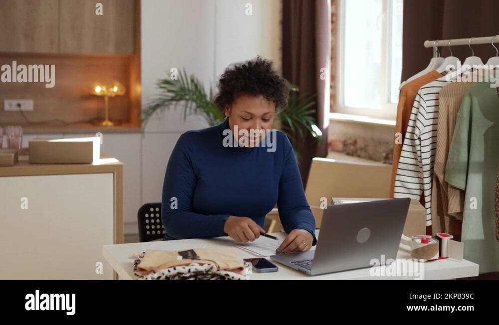 Young female manager is filling out shipping form and making call at ...