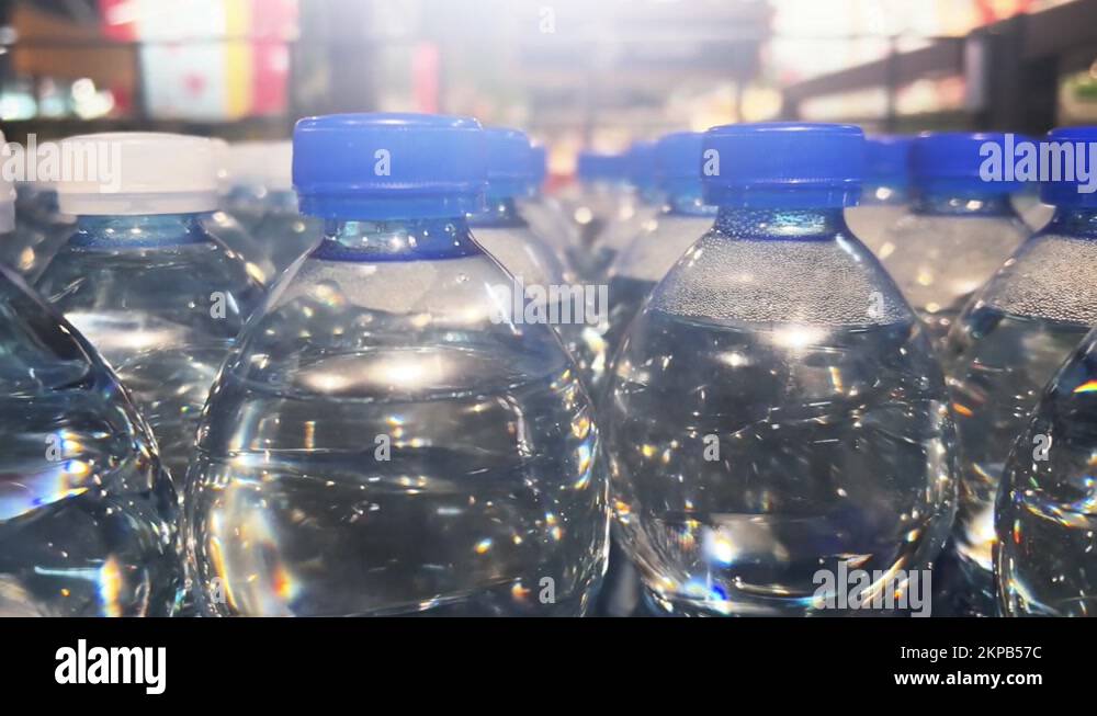 Mineral water in plastic bottles stands in rows in a supermarket or