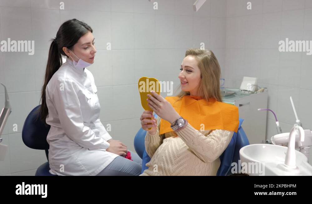A charming pregnant girl at a dentist appointment, smiles and looks in