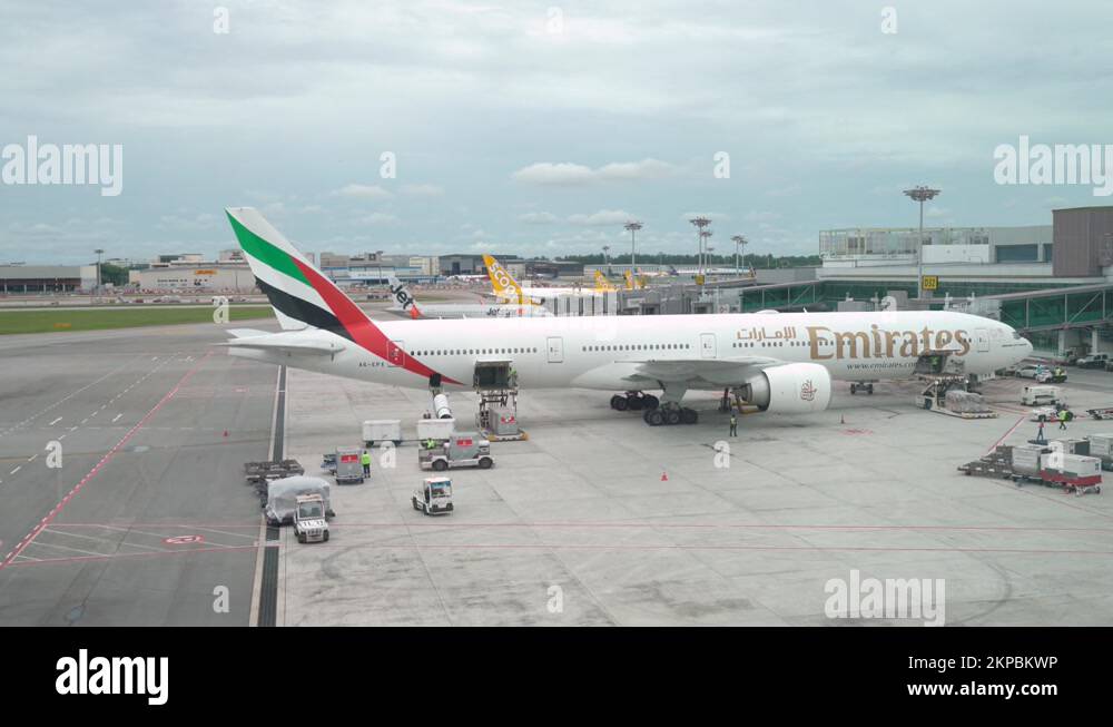 Airport Workers Loading Baggage On Emirates Airplane At Terminal