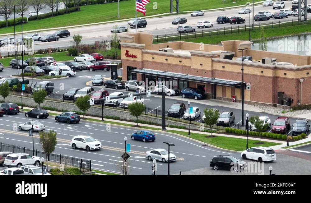 Busy ChickFilA. Aerial zoom reveals USA flag and road signs to Stock