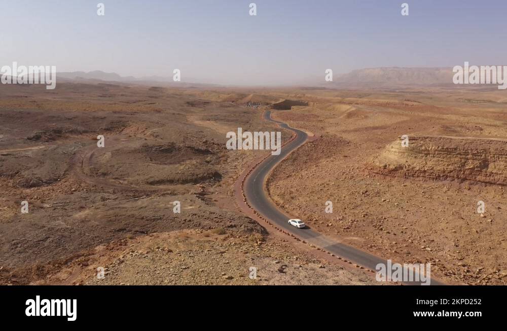 Drone flight of car driving through Makhtesh Ramon crater, Negev desert Israel Stock Video