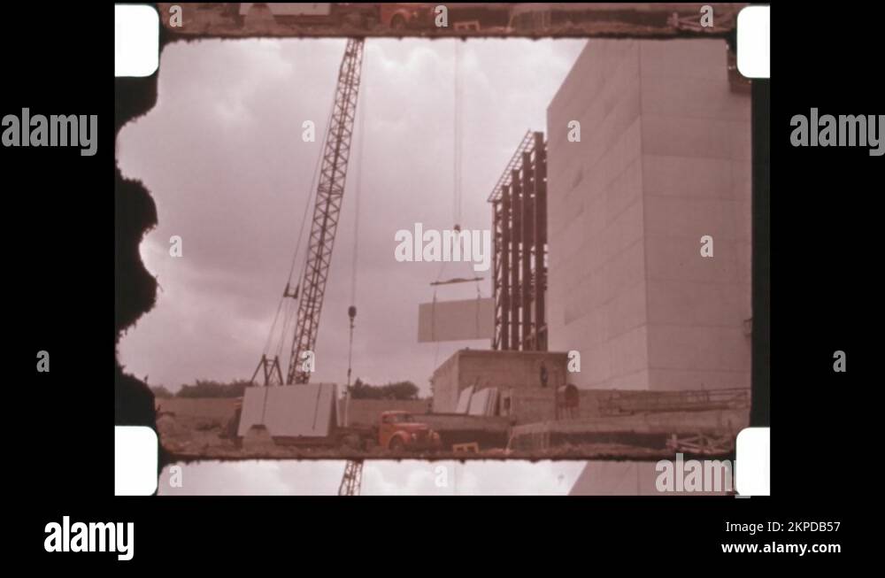 1960s Crane lifts section of wall for building on construction site